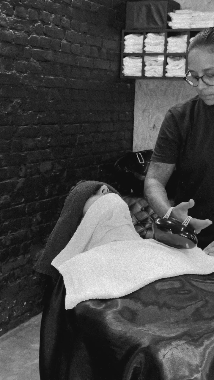 Atendimento de barba na Pamplona com cliente reclinado e profissional ao lado